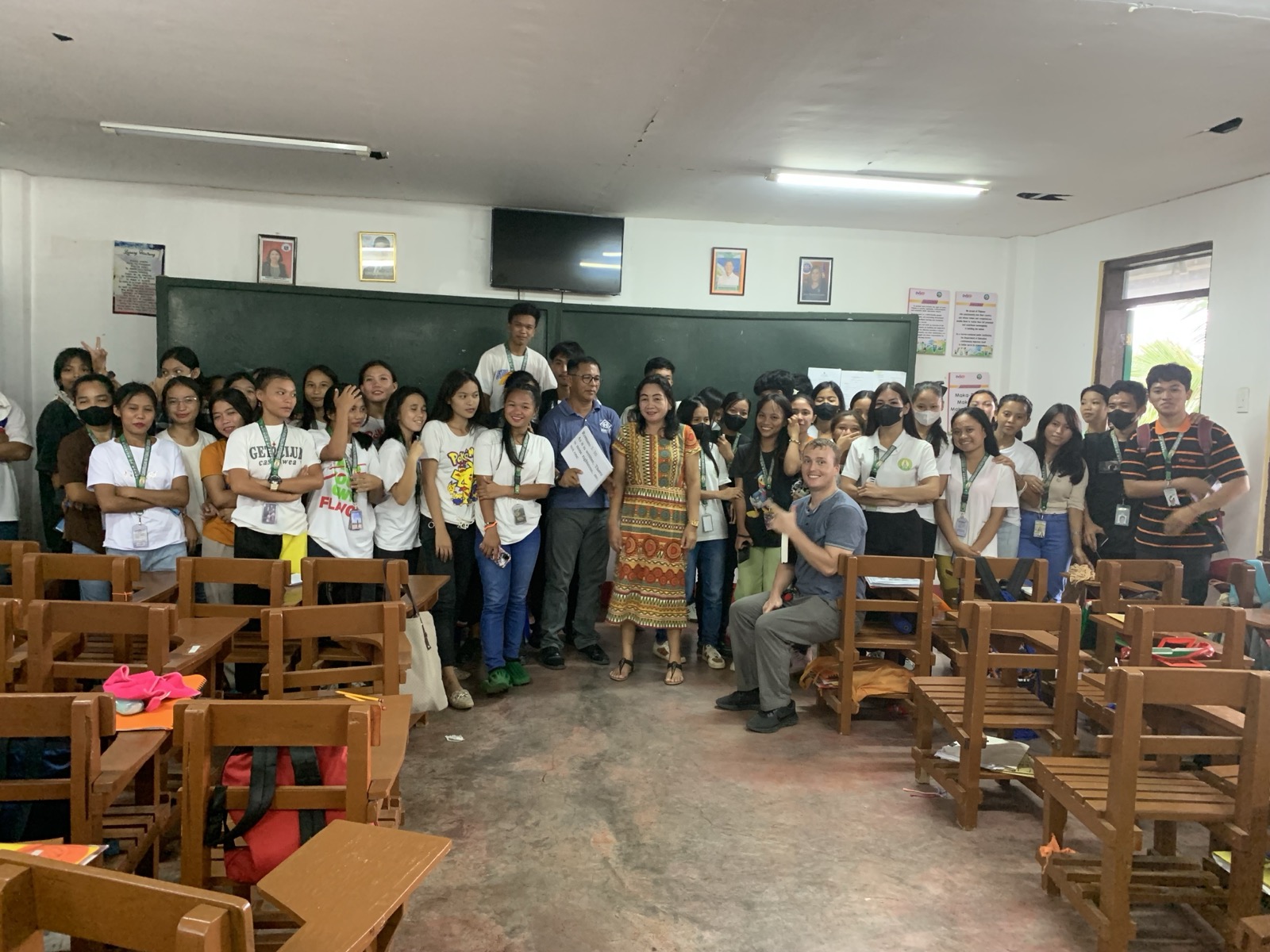 A full classroom of Filipino high school students with Collin and teachers, posing after a gospel presentation