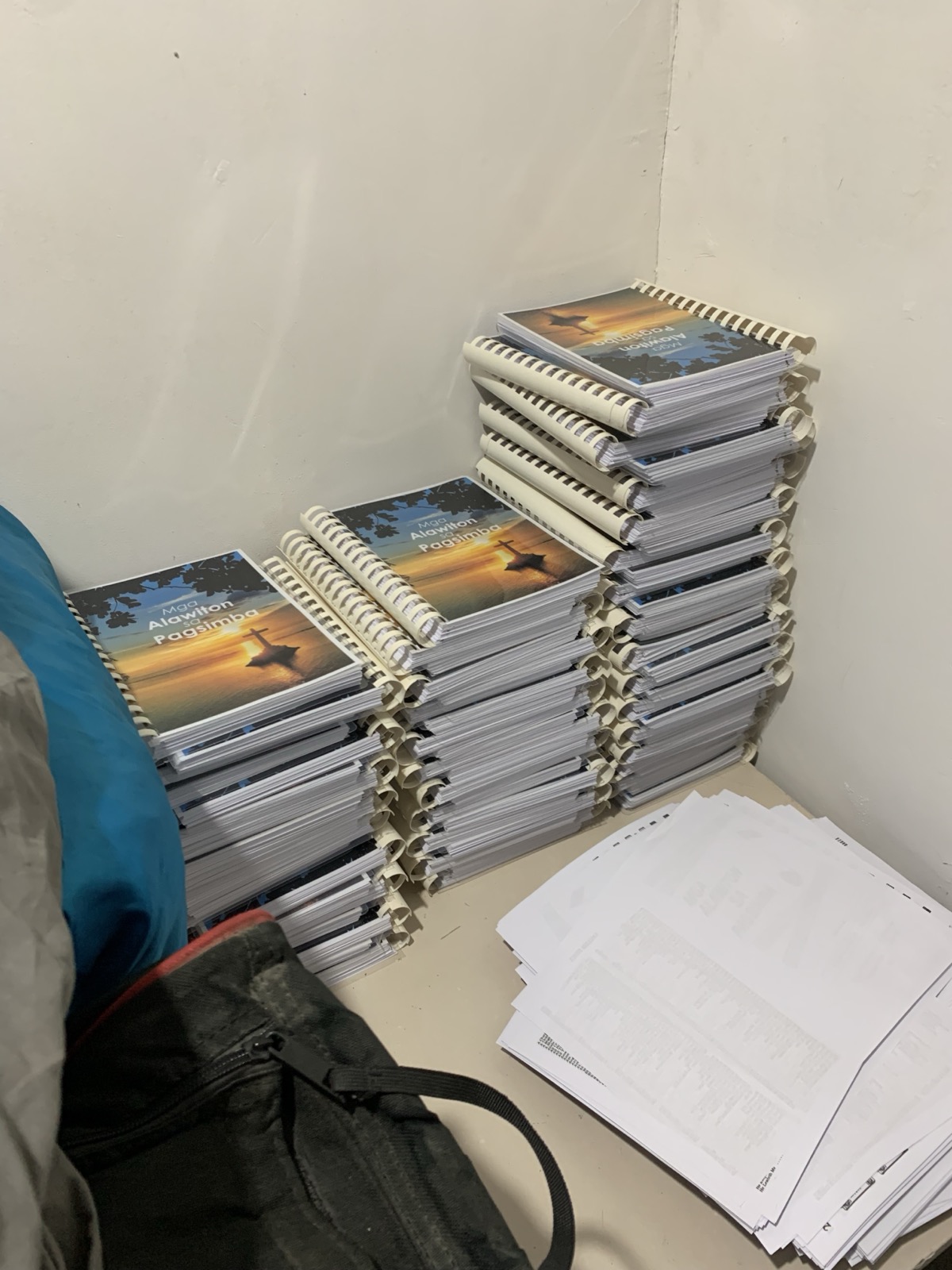 Large stacks of Filipino hymnals titled Mga Alawiton sa Pagsimba ready to deliver to local Baptist congregations