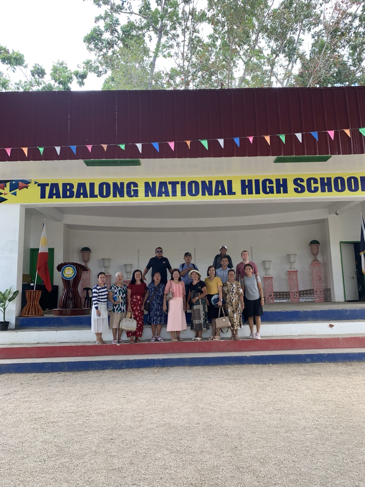 The Schneide team standing under the Tabalong National High School marquee after a ministry visit
